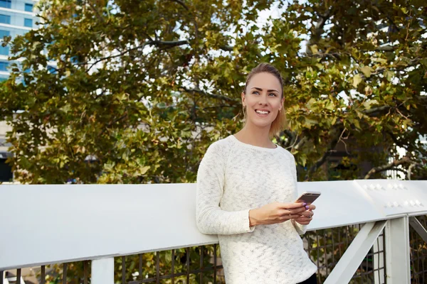 Frau steht mit Handy — Stockfoto