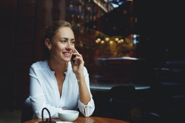 Cheerful female talking on mobile phone