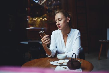 woman reading text message on cell telephone