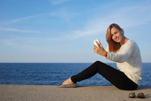 Hipster girl making photo on mobile phone — 图库照片