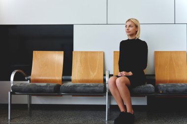 woman sitting in office hallway