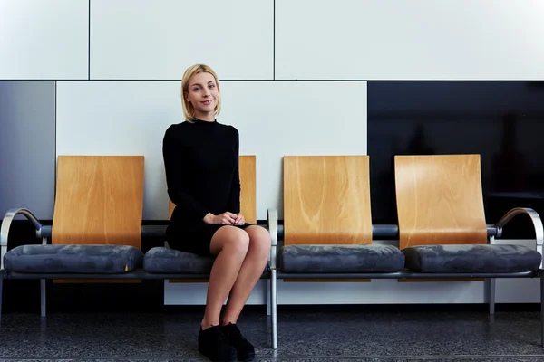 Frau sitzt auf Büroflur — Stockfoto
