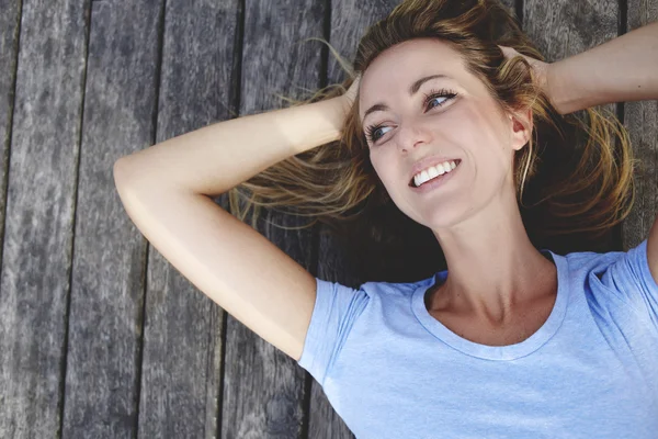 Woman lying on wooden floor — Stock Photo, Image