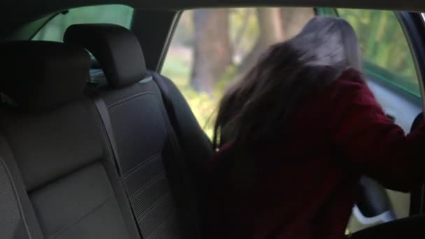 Młoda kobieta wysiada z fotela pasażera taksówki. — Wideo stockowe