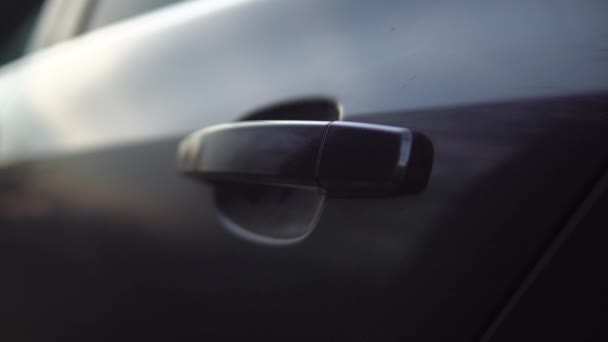 Porte ouverte à la main et femme entrant dans la voiture, assise sur le siège passager — Video