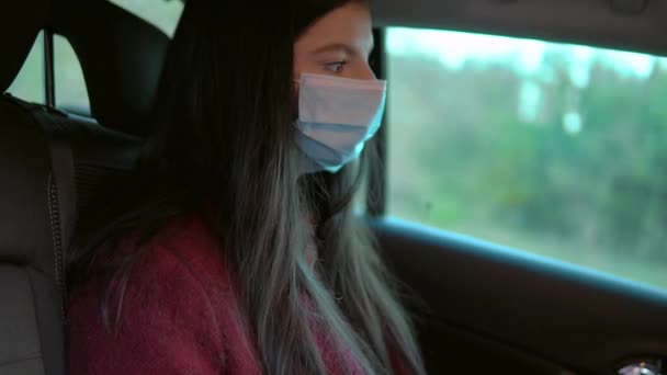 Attractive woman in protective mask in moving taxi car on passenger seat — Stock Video