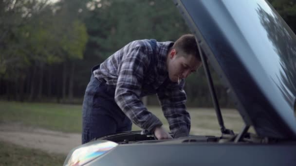 Mechanik z naprawianiem papierosów samochód awaryjny na drodze leśnej, złe habbits — Wideo stockowe