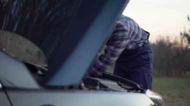 Mechanic fixing broken car, open hood, service stations worker finished repairs