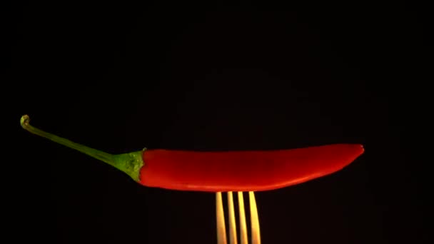Червоний гострий перець чилі на фоні фроку у вогні, чорний фон — стокове відео