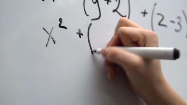 Student doing mathematic exercises on whiteboard, writing math equation close up — Stock Video