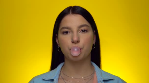 Vrouw kauwen en blazen roze kauwgom snoep, kijken naar camera, portret — Stockvideo