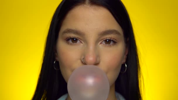 Attractive woman looking at camera, blowing bubble gum, smiling female portrait — Vídeos de Stock