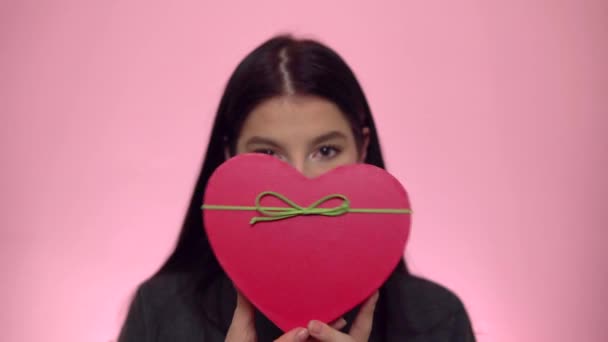 Sevgililer Günü. Çekici kadın kalp şeklinde bir hediye kutusu tutuyor.. — Stok video