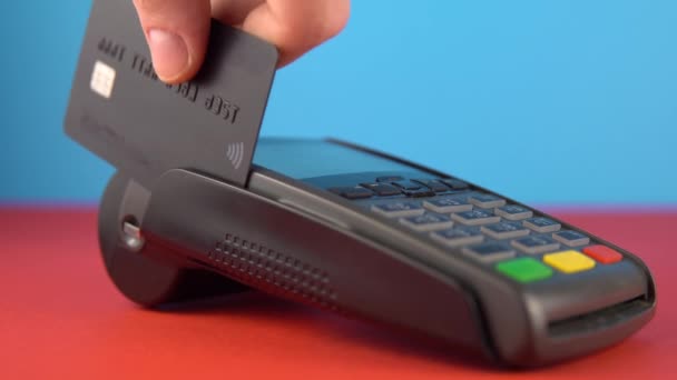 Nahaufnahme Hand, Zahlung, Terminal verwenden, um Konto zu bezahlen, farbiger Hintergrund — Stockvideo