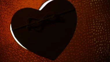 Bokeh Heart 'taki hediye kutusu kırmızı arka planı aydınlatıyor. Sevgililer Günü konsepti