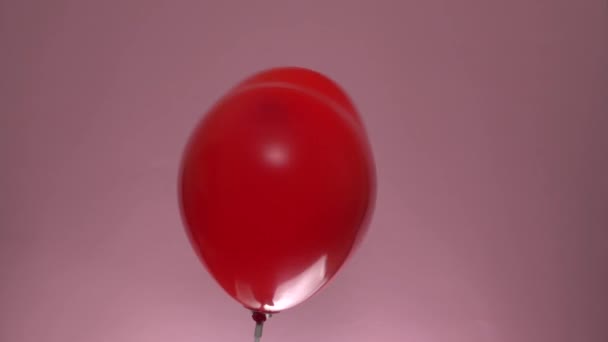 Röd ballong med hjärtform rotera på rosa bakgrund St. Alla hjärtans dag koncept — Stockvideo