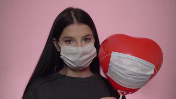 Triste femme en masque de protection regardant la caméra. Concept de Saint Valentin gâté — Video