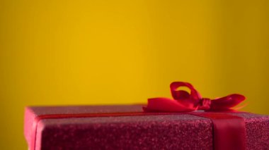Kırmızı hediye kutusu rotasyonu. Tatil hediyesi, yakın çekim. 360 derece döndürme.