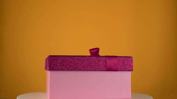 Holiday present box on color background. Gift box on rotation table. — Stock Video