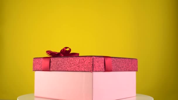 Boîte cadeau de vacances rotation sur fond jaune. Présent sur la table de rotation. — Video