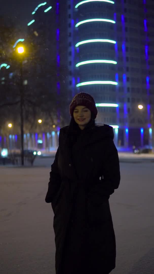 Mujer emocionada por las nevadas, invierno caminando por la ciudad. Vídeo vertical — Vídeos de Stock