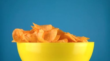 Patates cipsi servis masasında, mavi arka planda. Atıştırmalıklar, sağlıksız fast food
