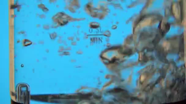Água fervida em chaleira de vidro elétrica na mesa de rotação, câmera lenta, close-up — Vídeo de Stock