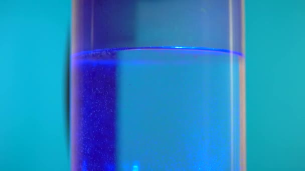 Διαφανές ηλεκτρικό βραστήρα σε περιστρεφόμενο τραπέζι, μπλε φόντο — Αρχείο Βίντεο