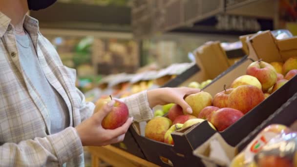 Mulher no supermercado escolhendo maçãs, prateleiras de frutas nos mercados. Sem plástico — Vídeo de Stock