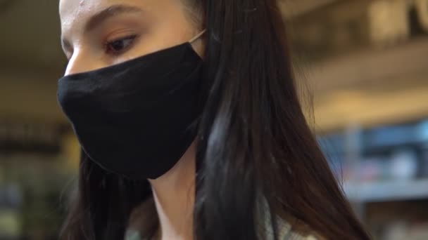 상품을 고르는 여성. 보안경을 쓰고 슈퍼마켓에서 걷는 모습 — 비디오