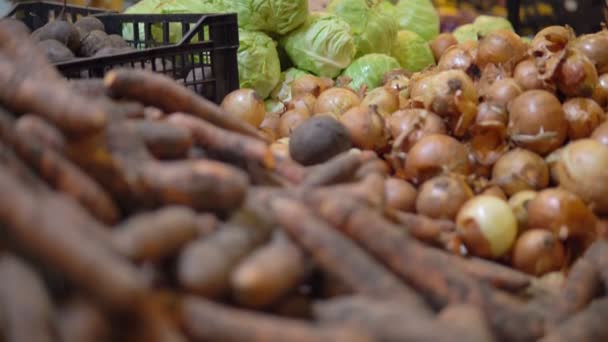 Vrouw die groenten koopt in supermarkt, wortel, ui en kool op planken. — Stockvideo