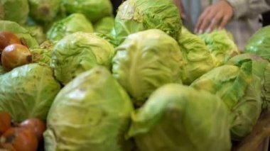 Süpermarkette lahana seçen bir kadın. Taze sebzeler, vejetaryen organik yiyecekler.