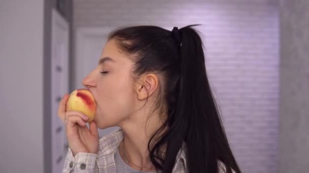 Friska kvinna biter saftig persika på nära håll. Video med ljud. — Stockvideo