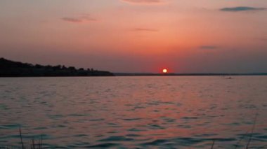 Nehir sahilinde gün batımı. Doğa arkaplanı, dalgalar kapanır.