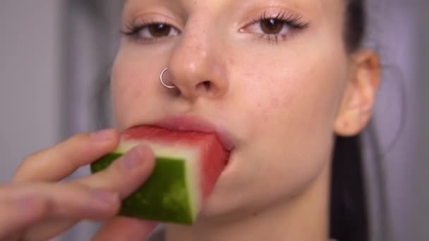 Женщина кусает арбуз вблизи, ест фрукты — стоковое видео