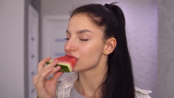 Attraktive Frau beißt Wassermelonenscheibe, sagte YAMMY. Mädchen isst Früchte. — Stockvideo