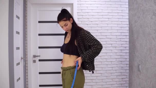 Lös vikt och bantning. Kvinna som mäter sin midja och ler. — Stockvideo