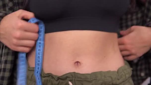 Abdomen de cerca. Mujer midiendo su talla de cintura. Concepto de peso suelto — Vídeos de Stock