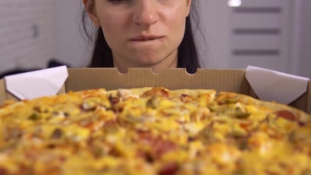 Een boze dieetvrouw die naar pizza kijkt. Fast food eten, genieten van smakelijke maaltijd. — Stockvideo