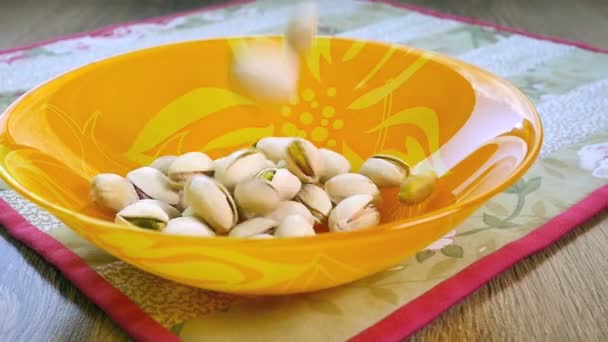 Pistachio nuts falling into bowl, slow motion — Stock Video
