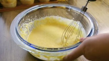 Closeup un ile zaten kadar dövülmüş yumurta ve şeker bir el mikseri kullanarak karıştırma