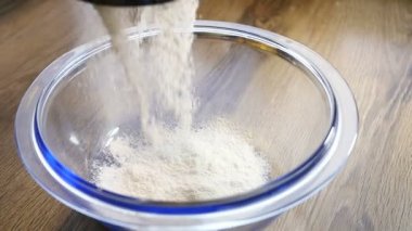 Metal bir elekten düşen rafine beyaz pasta unu ince bir perde kapat