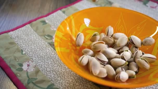 Фисташковые орехи падают в миску, замедленная съемка — стоковое видео
