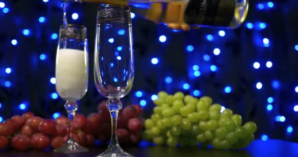 Пузырьковое шампанское наливают в два хрустальных бокала на чёрном фоне. — стоковое видео