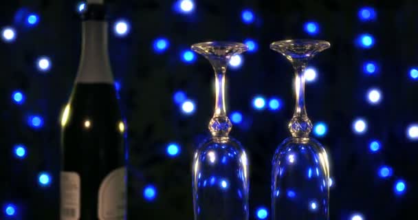 Verres vides et bouteille de champagne sur le fond bleu boke — Video