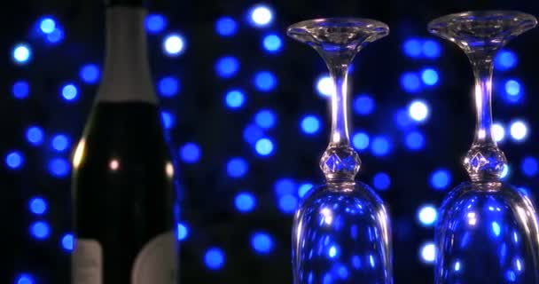 Verres vides et bouteille de champagne sur le fond bleu boke — Video