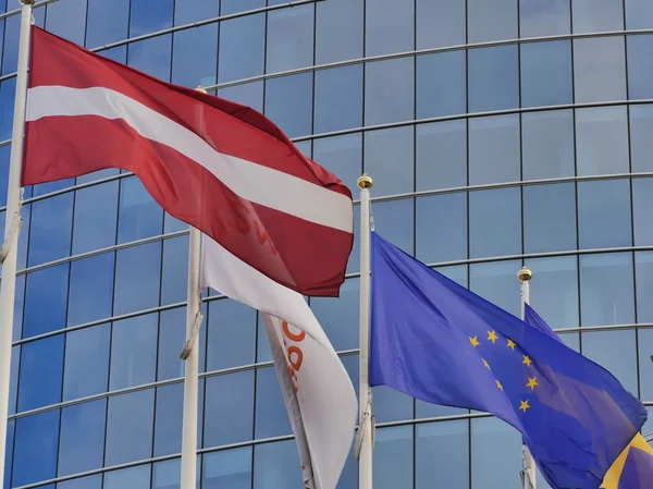 Drapeaux de nombreux pays sur le bâtiment en verre bleu — Photo