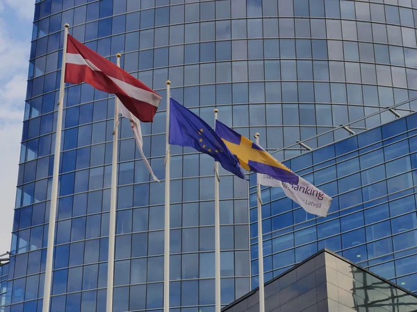 Bandeiras de muitos países no edifício de vidro azul — Fotografia de Stock