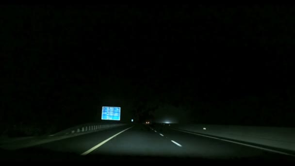 El exceso de velocidad en la autopista a través de la pequeña ciudad en las nubes de niebla por la noche — Vídeos de Stock