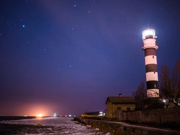 Zwart-wit vuurtoren bij nacht in de Baltische Zee strand — Stockfoto